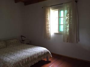 新彼得罗波利斯Sitio da Paz Celestial的一间卧室设有一张床和一个窗口