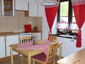 顺佩尔克Chalupa Hrabišín的厨房配有一张带红白桌布的桌子