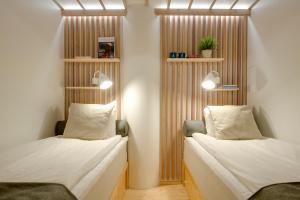 坦佩雷坦佩雷梦想旅舍的配有木制隔板的客房内的两张床