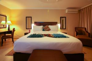 TeshiBest Western Plus Accra Beach Hotel的卧室配有一张大白色的床和书桌