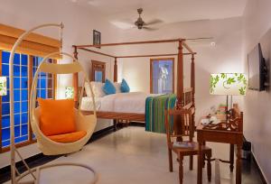 蓬蒂切里Villa Krish的卧室配有秋千床和椅子。