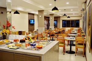 大坎普布鲁马杜酒店的一间餐厅配有桌椅,提供食物