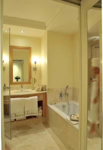 贝叶拉勒别墅酒店的带浴缸、水槽和镜子的浴室