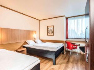 艾森纳赫爱森纳赫宜必思酒店的酒店客房,设有两张床和一张红色椅子