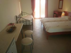 特拉佩扎奇阿尔吉奥尼一室公寓的酒店客房带两张床和一张桌子以及椅子。