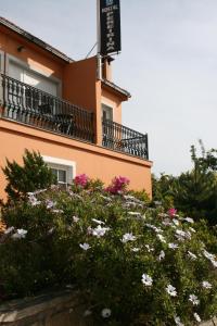 塞埃佩雷林尼亚酒店的前面有粉红色和白色花的建筑