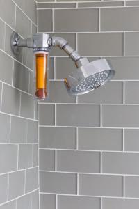 楠塔基特21布罗德酒店的浴室内装有橙色瓶子的淋浴水龙头