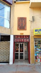 卡拉马Hotel Quitor的建筑前有标志的商店