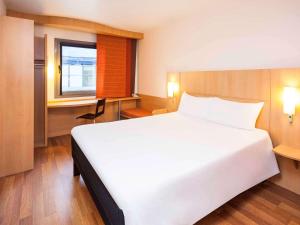阿尔考本达斯宜必思马德里阿尔克贝达斯酒店的卧室设有一张白色大床和一扇窗户。