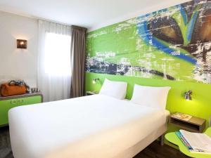 维勒班Ibis Styles Lyon Villeurbanne Parc de la Tête d'Or的卧室配有白色的床和绿色的墙壁