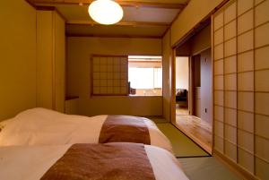 高山Miyama Ouan Kyoritsu Resort的一间卧室设有一张床和一个窗口