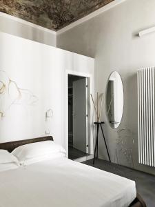 都灵卡斯泰洛广场套房公寓式酒店的白色卧室配有床和镜子