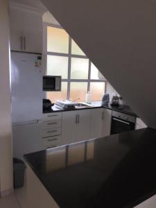 乌姆德洛蒂20 Mallorca Duplex的厨房配有黑色台面和窗户