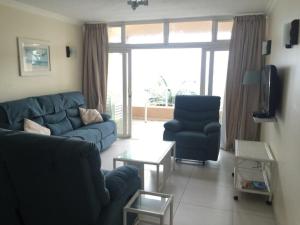 乌姆德洛蒂20 Mallorca Duplex的客厅配有蓝色的沙发和两把椅子