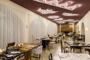曼杜里亚Vinilia Wine Resort的一间带桌椅和天花板的用餐室