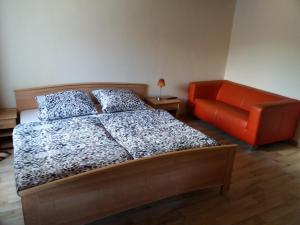 巴哈拉赫司提阁韦恩斯塔博酒店的一间卧室配有一张床和一张橙色椅子