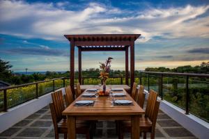 乌鲁瓦图巴厘岛独家别墅的阳台上配有一张带椅子的木桌