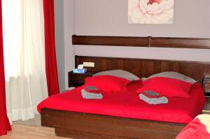 蒙多夫莱班Hotel Restaurant Le Paris的一间卧室配有红色的床和红色枕头