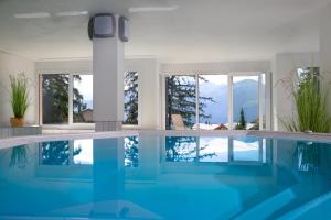 克莱恩 蒙塔纳海尔维蒂亚公寓式酒店的蓝色的游泳池和窗户