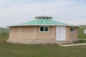 NalayhNomad Horse Camp的一座小建筑,在田野上拥有绿色屋顶
