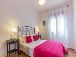 塔里法La Casa Del Polo- Alltarifa的一间卧室配有一张带粉色毯子的大床