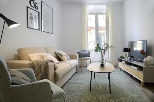 马德里nQn Aparts & Suites Madrid的客厅配有沙发和桌子