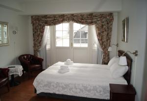 拉尔维克特鲁温杰西加德酒店的一间卧室设有一张大床和窗户