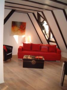 美因茨Appartement Kirschgarten Mainz Rochusstraße的客厅配有红色的沙发和桌子