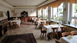 洪堡布尔格霍夫酒店的餐厅设有白色的桌椅和窗户。