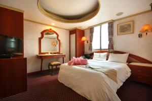 苗栗市王府大饭店的酒店客房,配有床和镜子