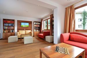 蒂罗尔-基希贝格Gasthof Skirast的客厅配有红色的沙发和桌子