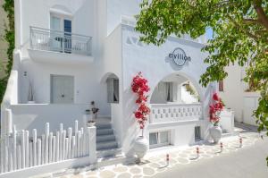 纳克索乔拉Naxos Evilion Luxury Apartments & Suites的白色的建筑,白色的楼梯和花花花花