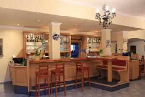 Hatzenport哈赛波特天堂酒店的餐厅内的酒吧配有椅子和柜台