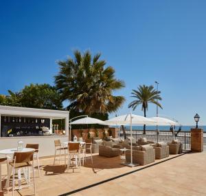 锡切斯Hotel Casa Vilella 4* Sup的一个带桌椅和遮阳伞的庭院