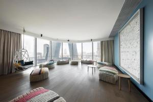 北京JEN北京新国贸饭店-香格里拉集团的带沙发和椅子的客厅以及大窗户。