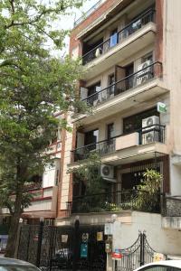 新德里生活树住宿加早餐酒店的城市街道上带阳台的公寓大楼