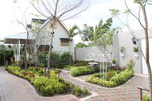 莱卡邦At Residence Suvarnabhumi Hotel - SHA Extra Plus的房屋前的花园