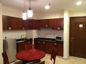 士姑来兰斯度假租赁公寓的厨房配有木制橱柜和红色桌子