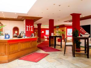 普劳恩普劳恩多梅洛酒店的餐厅大堂设有红色柱子和柜台