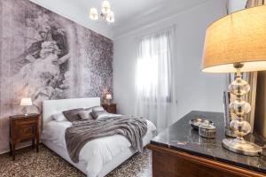 威尼斯Rialto Design Boutique Apartment R&R的卧室配有一张床,墙上挂有绘画作品