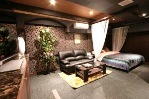 龟山萨瑞赛奇国际店（仅限成人）的一间带沙发、床和桌子的卧室