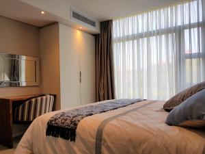 巴利托Zimbali Suites 109的一间卧室设有一张床和一个大窗户