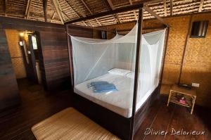 诗巫岛Rimba Resort - Dive Centre & Spa的一张带天蓬的床