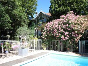 圣雷米普罗旺斯花花小木屋酒店的游泳池旁的粉红色花 ⁇ 