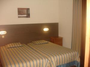 大里贝拉Hotel Ribeira Grande的一间卧室配有带条纹毯子的床