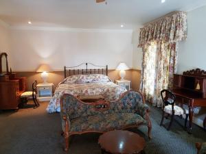 察嫩舍伍德乡间别墅酒店的一间卧室配有一张床、一张沙发和一把椅子