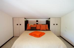 阿马尔菲天堂公寓的一间卧室配有一张带橙色枕头的大床