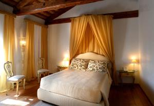 Gorgo al Monticano弗斯卡利尼科尔纳罗别墅的一间卧室配有一张带天蓬的床和两把椅子