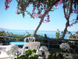 圣加利尼哈里克里亚旅馆的一张桌子和椅子,背景是大海