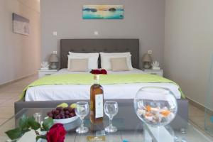 埃亚玛琳娜奈奇多Litinakis Studios的一间卧室配有一张床,提供一瓶葡萄酒和酒杯